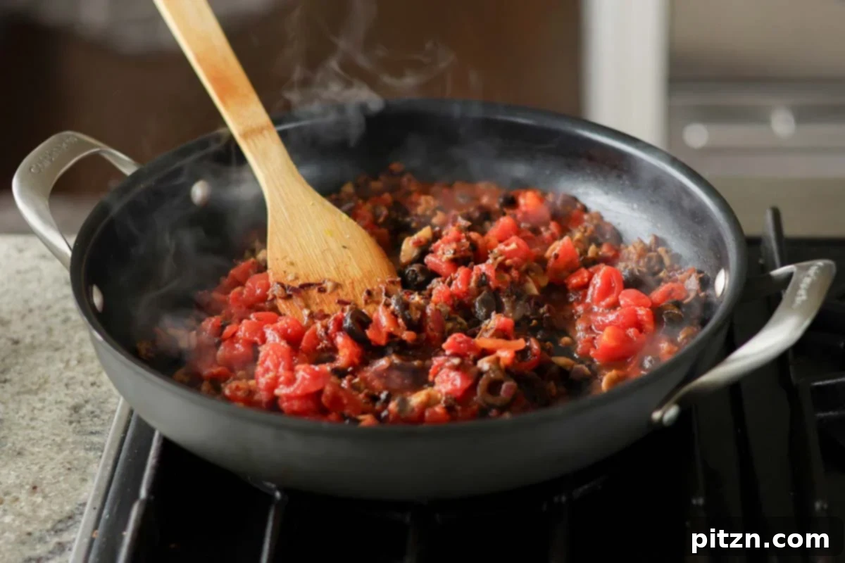 Zesty Mediterranean Butter Beans 13 adding chopped tomato to the pan