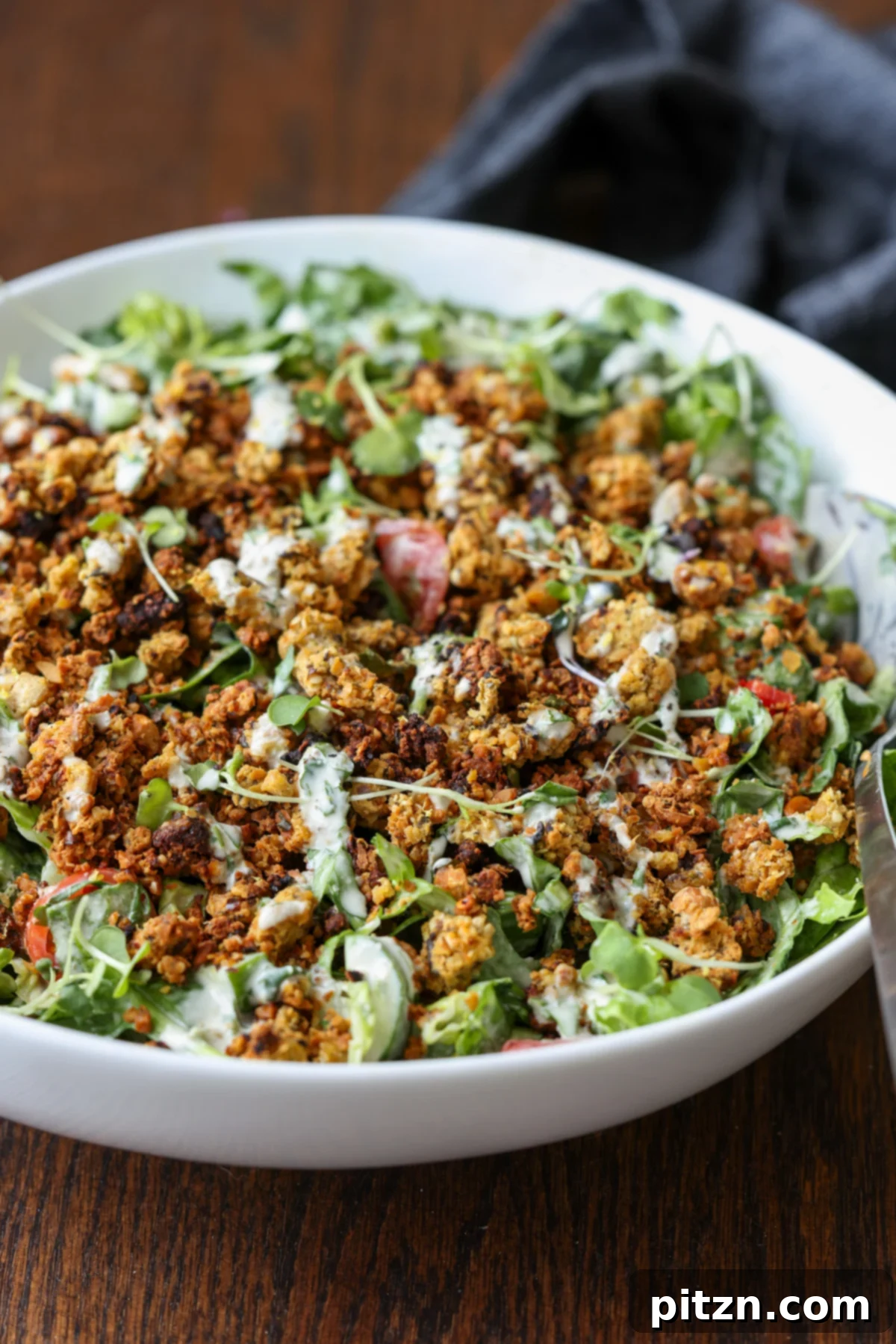 Sun-Drenched Spinach Salad with Zesty Olive-Chickpea Crunch 4 Summer spinach salad generously portioned in a serving bowl, ready to be enjoyed.