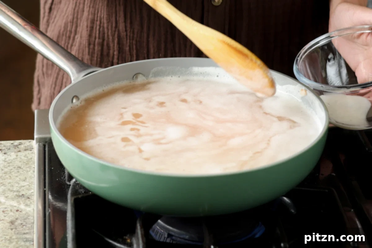 Lentil Protein World Tour Mix 11 Lentils boiling in a saucepan, with foam being skimmed from the surface.