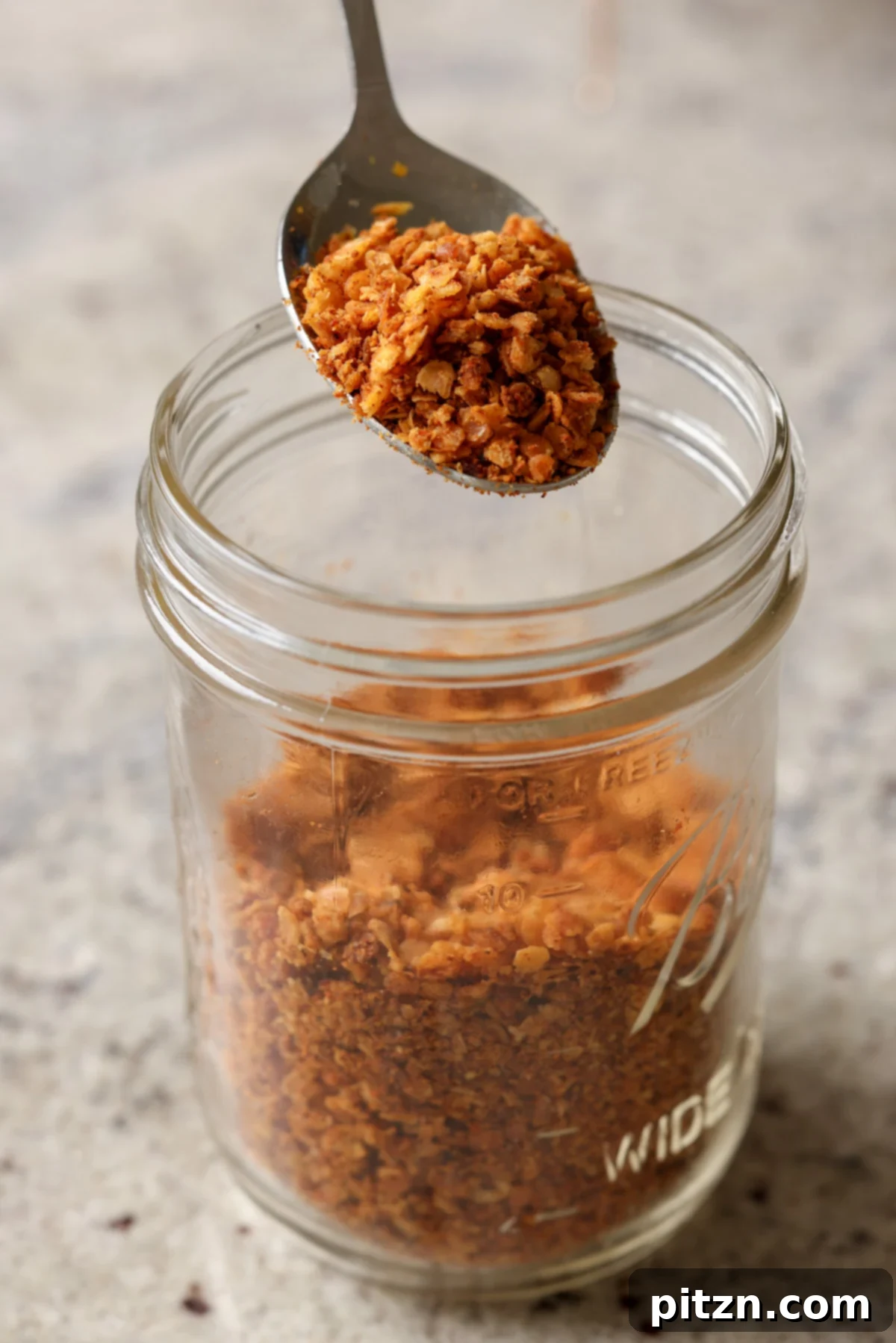 Lentil Protein World Tour Mix 3 Nacho cheese flavored lentil granola, presented enticingly in a glass jar.