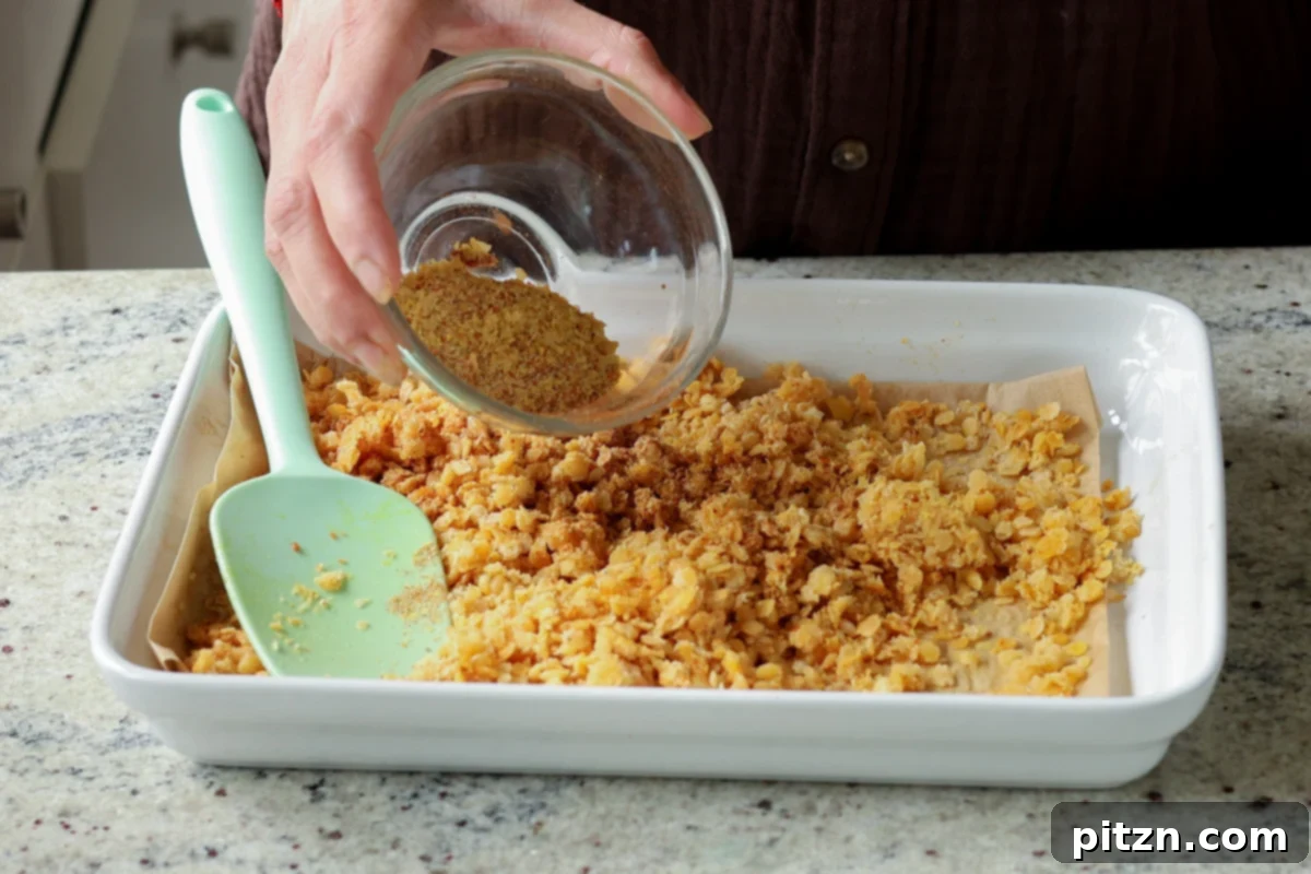 Lentil Protein World Tour Mix 29 Adding nacho cheese spice mix to the lentils on the baking pan.