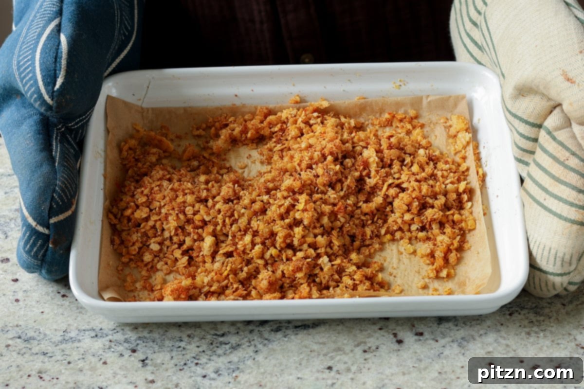 Lentil Protein World Tour Mix 30 Nacho cheese lentil granola spread on a baking pan before baking.