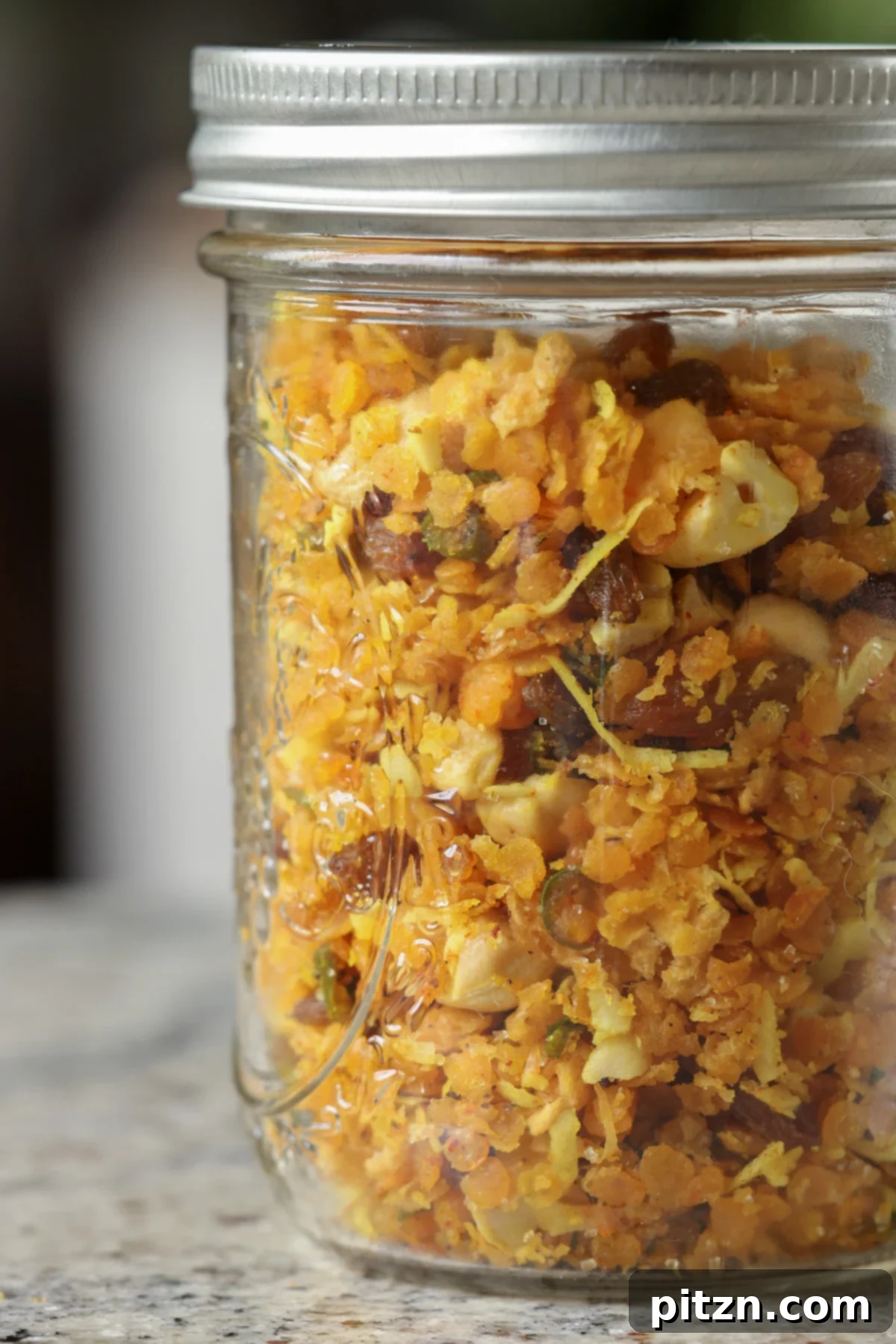 Lentil Protein World Tour Mix 5 Indian-spiced savory lentil granola, elegantly presented in a glass jar.