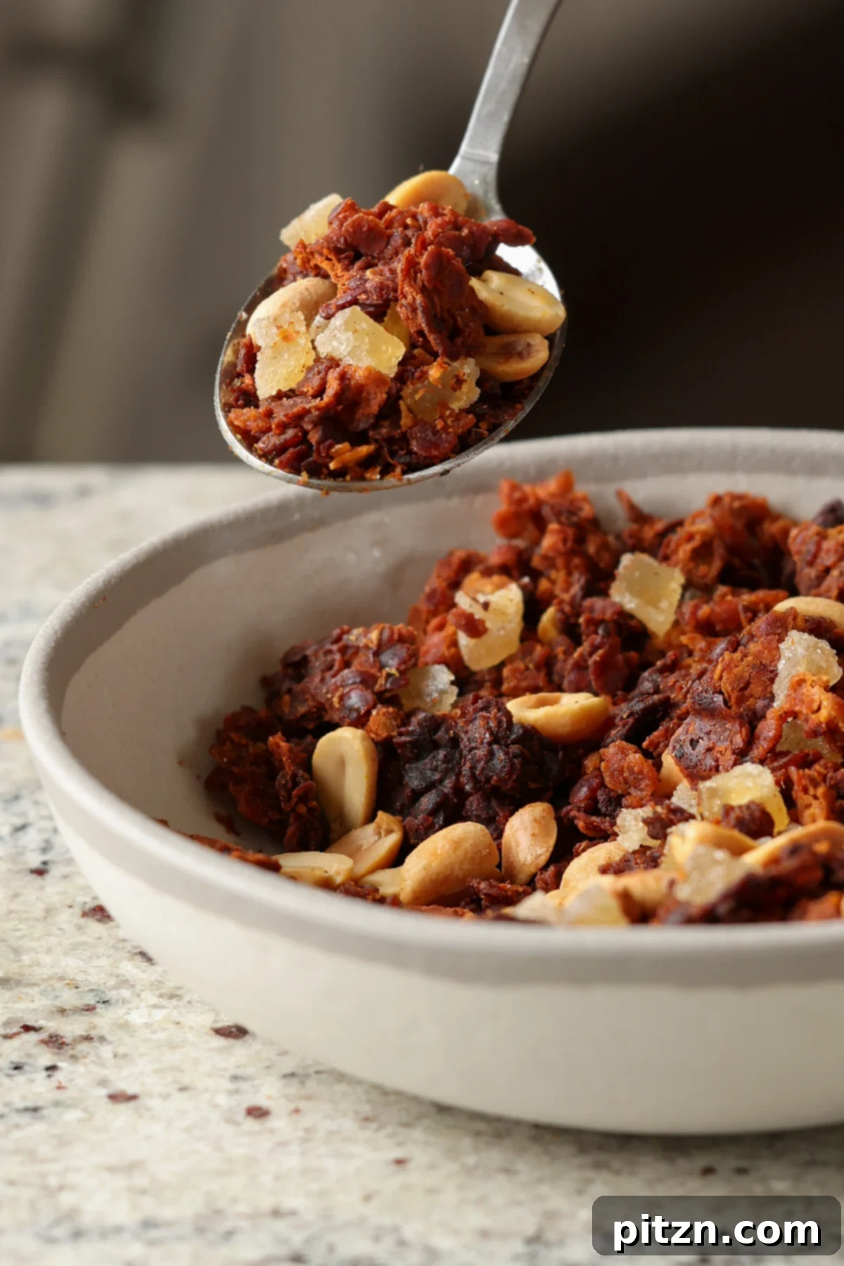Lentil Protein World Tour Mix 6 A spoon scooping a delicious bite of Peanut Gochujang savory lentil granola.
