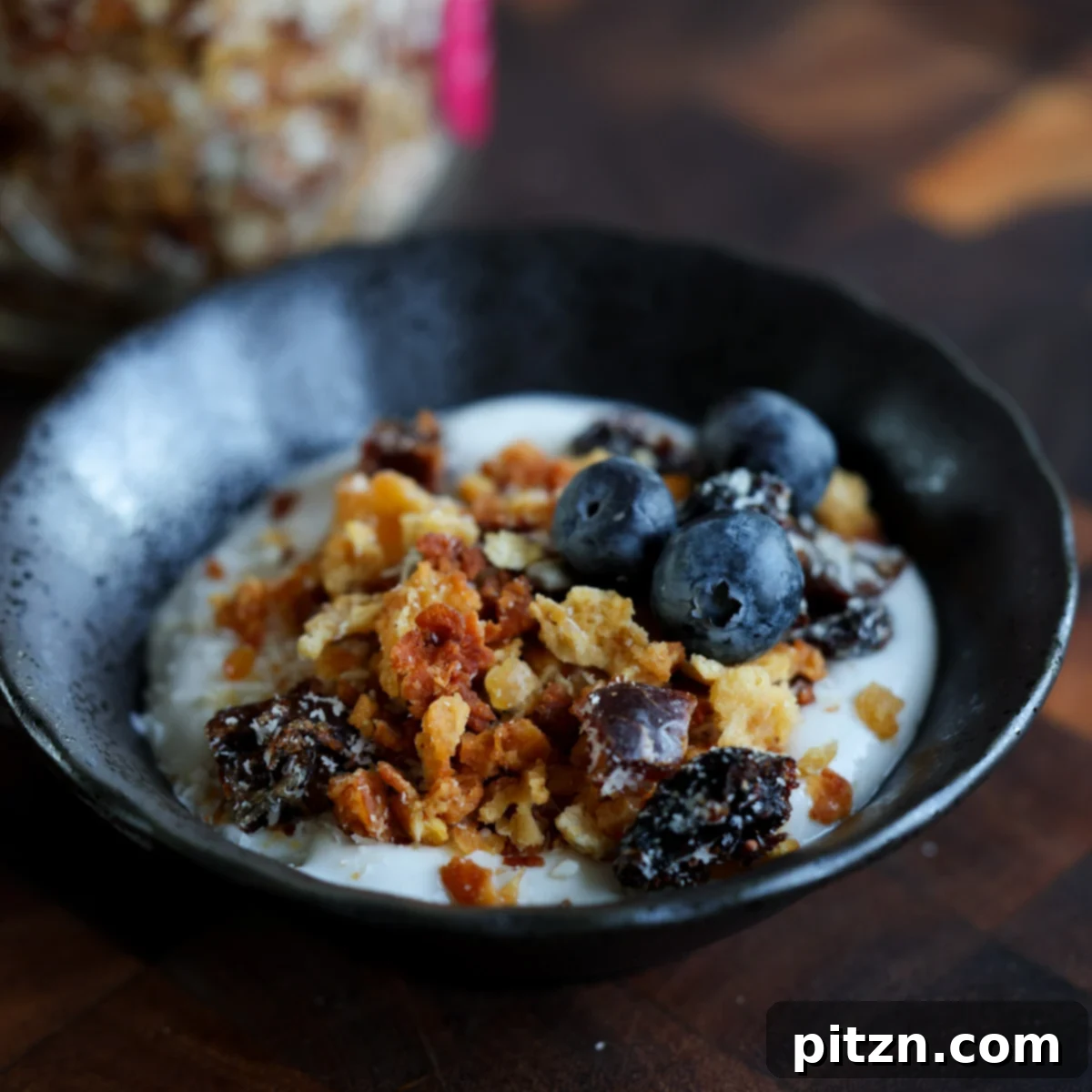 A beautiful bowl of non-dairy yogurt topped generously with homemade red lentil granola