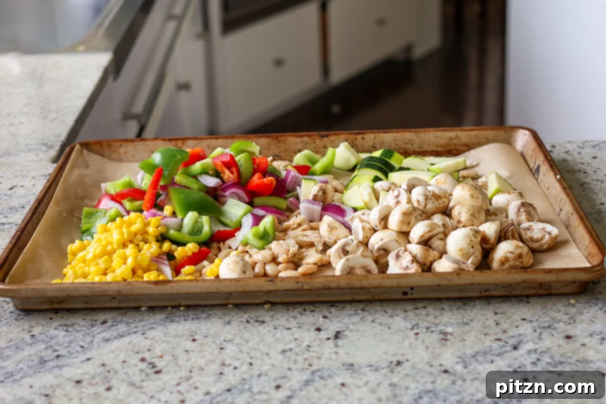One-Pan Smoky Cajun Veggies and Smashed White Beans 10 adding the veggies to the sheet pan