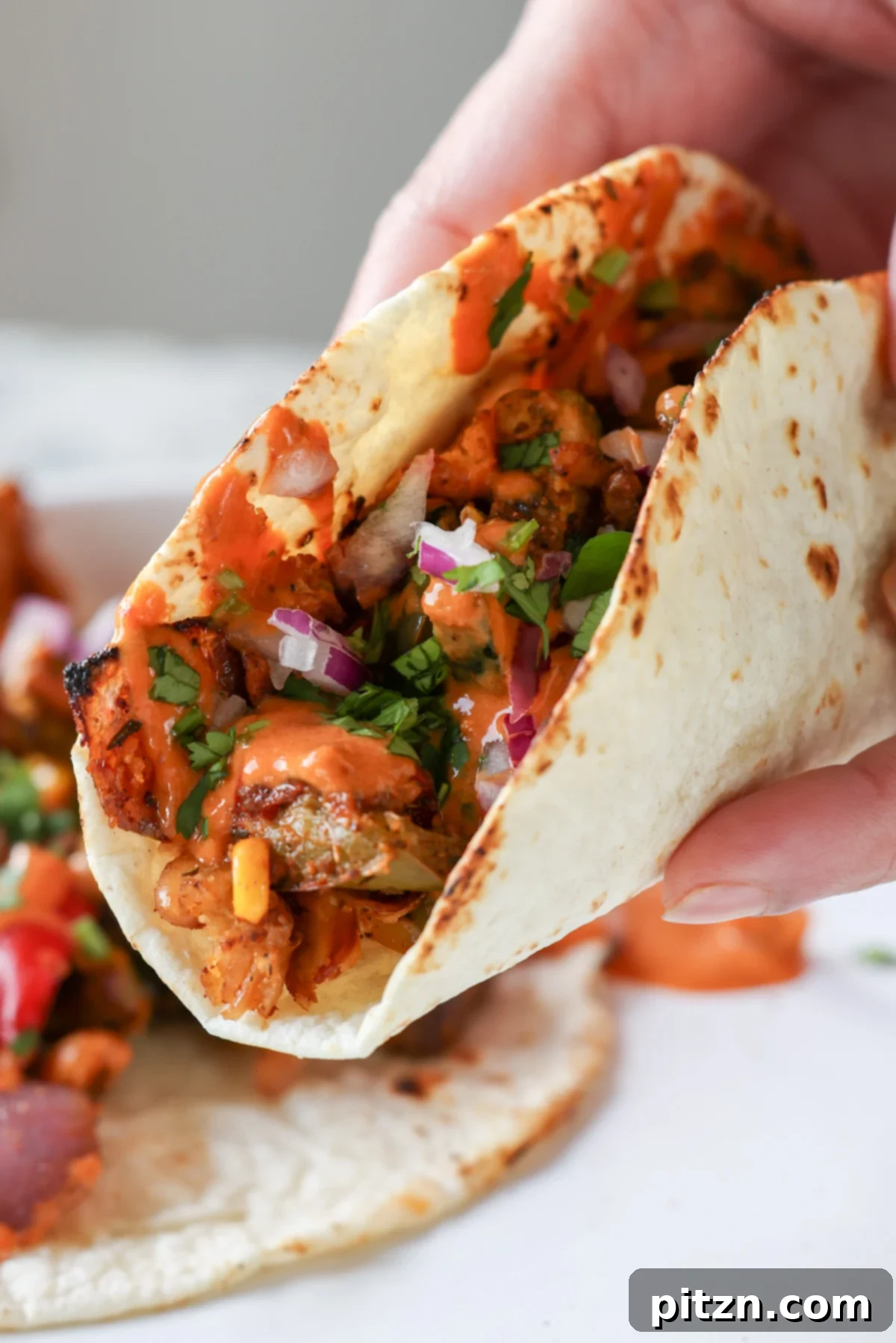 One-Pan Smoky Cajun Veggies and Smashed White Beans 3 tortilla stuffed with cajun sheet pan beans veggies