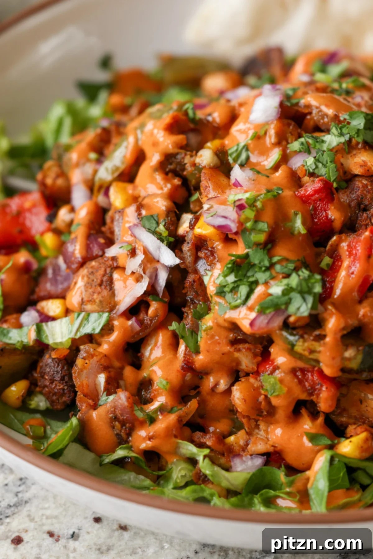One-Pan Smoky Cajun Veggies and Smashed White Beans 5 close-up of cajun sheet pan beans veggies in a bowl