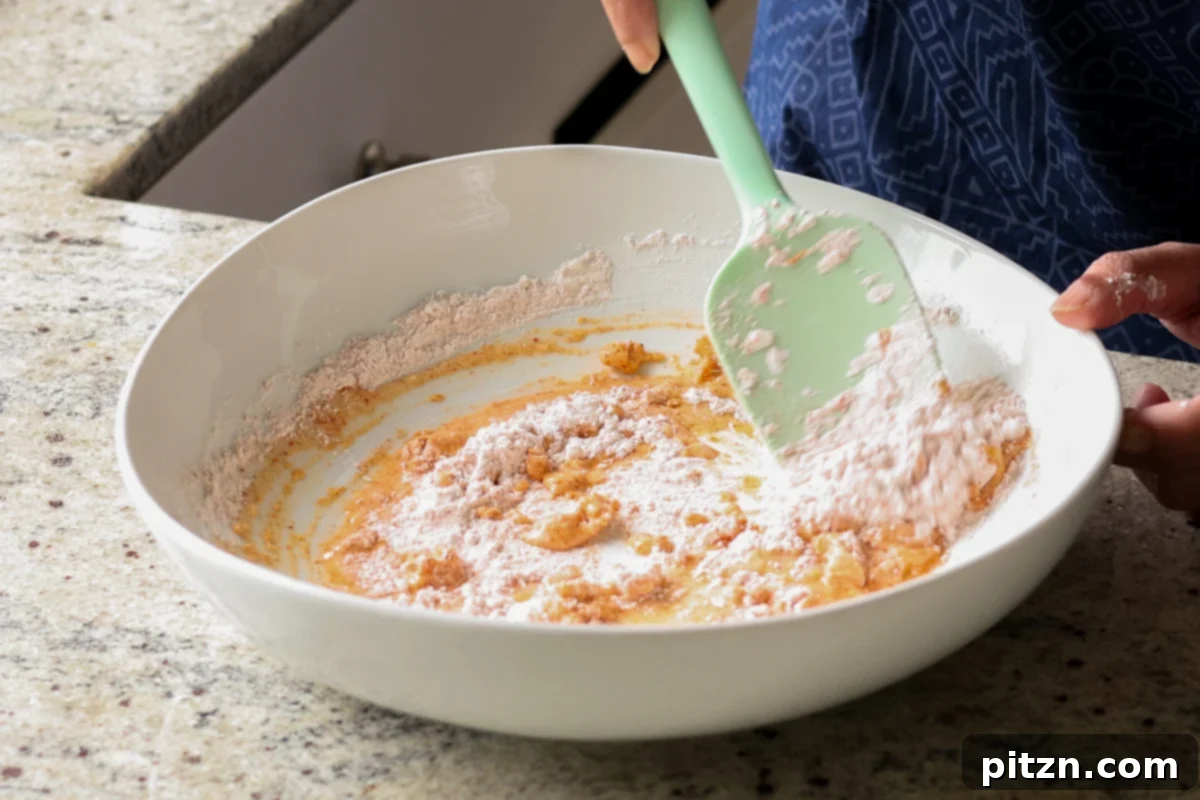 Crispy Vegan 555 Chicken Bites 11 Adding the dry cornstarch and spice mixture to the wet batter ingredients.