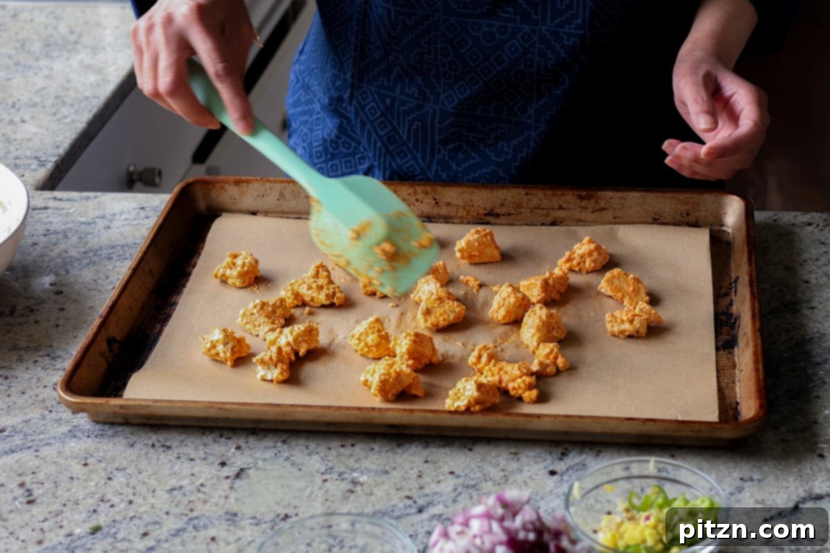 Crispy Vegan 555 Chicken Bites 15 Vegan Chicken 555 pieces spread on a baking sheet before baking.