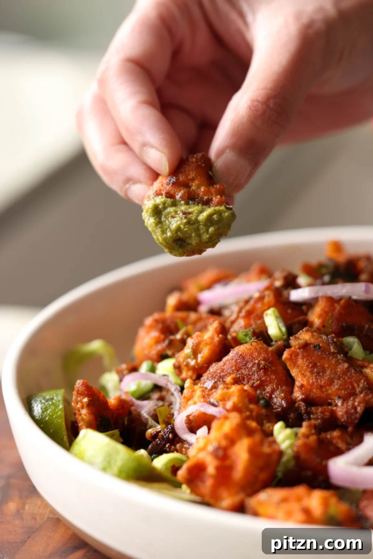 Crispy Vegan 555 Chicken Bites 3 A piece of crispy Vegan Chicken 555 being dipped into a refreshing cilantro mint chutney.