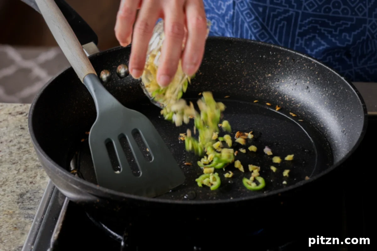 Crispy Vegan 555 Chicken Bites 20 Adding minced garlic, ginger, and green chilies to the pan, releasing their aromatic qualities.