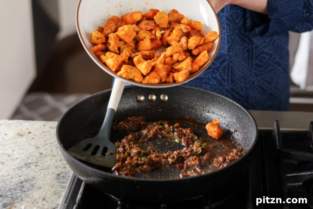 Crispy Vegan 555 Chicken Bites 25 Adding crispy tofu pieces directly into the simmering chicken 555 sauce.