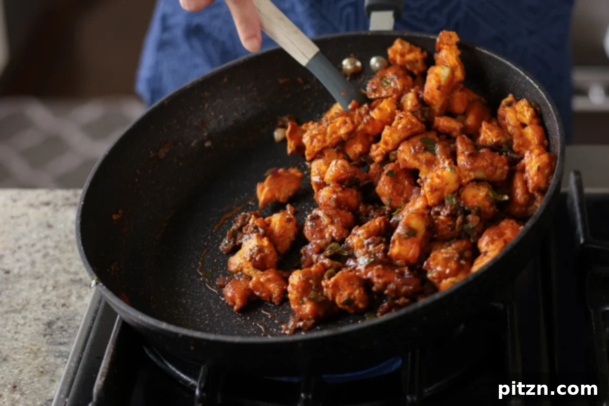 Crispy Vegan 555 Chicken Bites 26 Tossing the crispy vegan chicken 555 vigorously to coat it completely in the rich sauce.