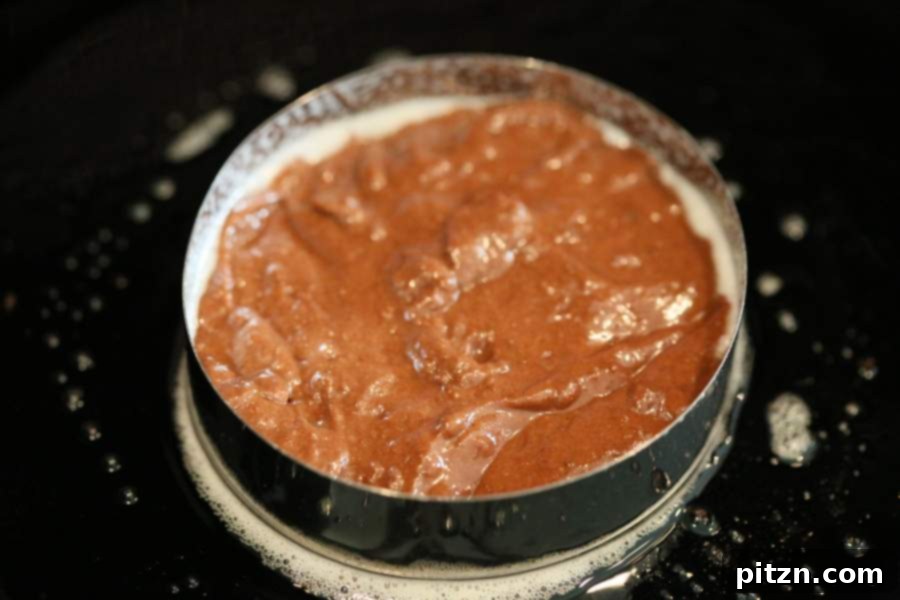Placing cookie cutter for stovetop chocolate cake layers