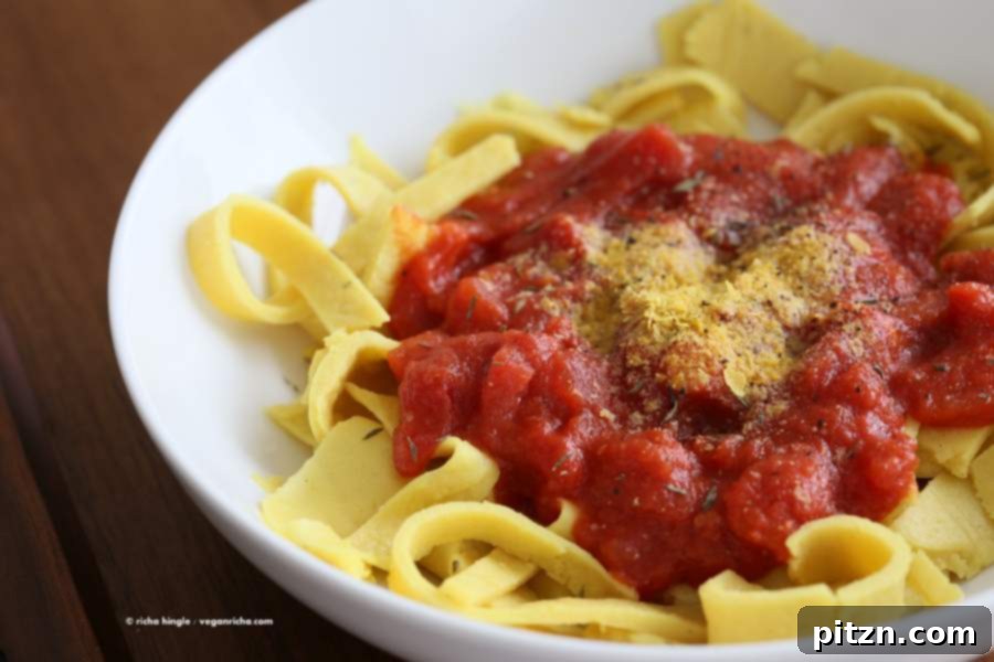Savory Garlic Tomato Sauce over Vegan Chickpea Pasta 11 A top-down view of a serving of Vegan Chickpea Noodles with tomato sauce, garnished with fresh basil leaves.