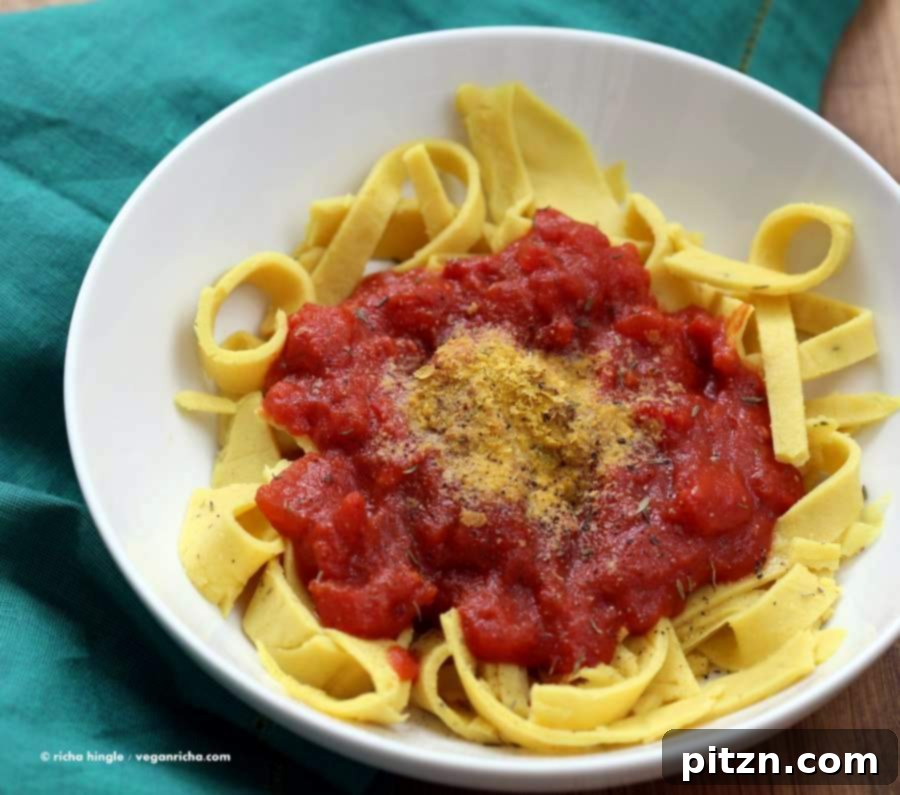 Savory Garlic Tomato Sauce over Vegan Chickpea Pasta 3 Close-up of freshly made Chickpea Noodles ready to be served with a delicious tomato sauce, highlighting the texture and appeal of this vegan dish.