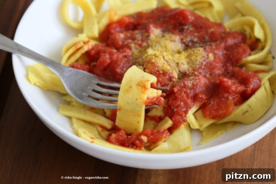 Savory Garlic Tomato Sauce over Vegan Chickpea Pasta 4 A vibrant close-up of Vegan Chickpea Noodles with red tomato sauce and fresh herbs, ready to be served.
