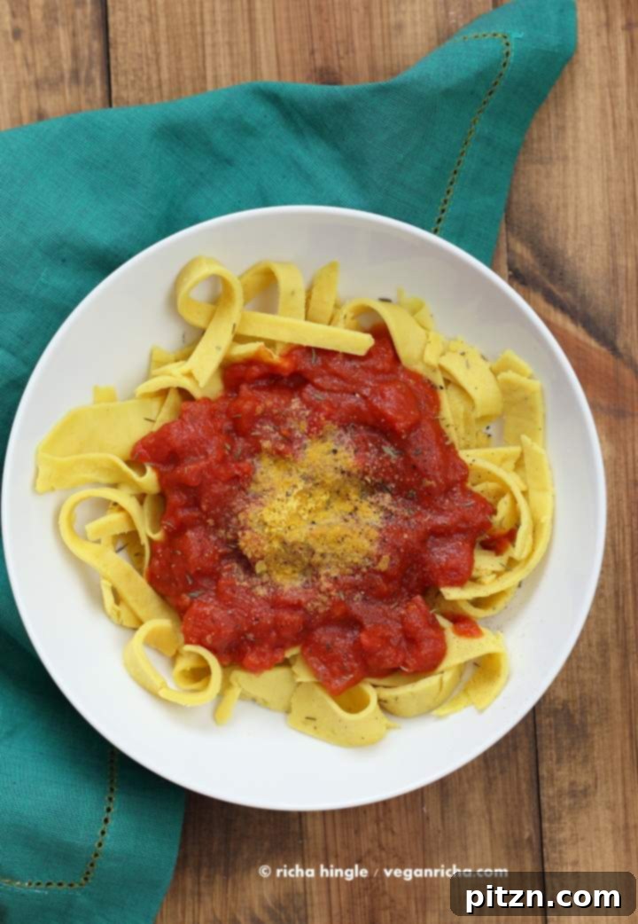 Savory Garlic Tomato Sauce over Vegan Chickpea Pasta 9 A beautifully plated dish of Vegan Chickpea Noodles with garlic tomato sauce, garnished with fresh toppings.