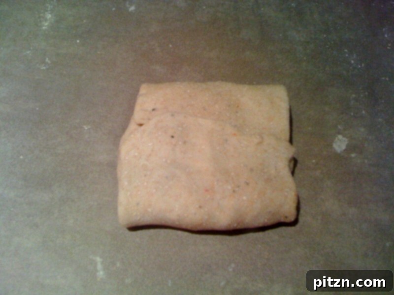 Mom's Aloo Paratha and Sanjeev Kapoor's Baghare Baingan A Flavorful Pairing 5 Close-up image demonstrating how to fold and seal the edges of the Aloo Paratha dough around the potato filling, forming a neat parcel.