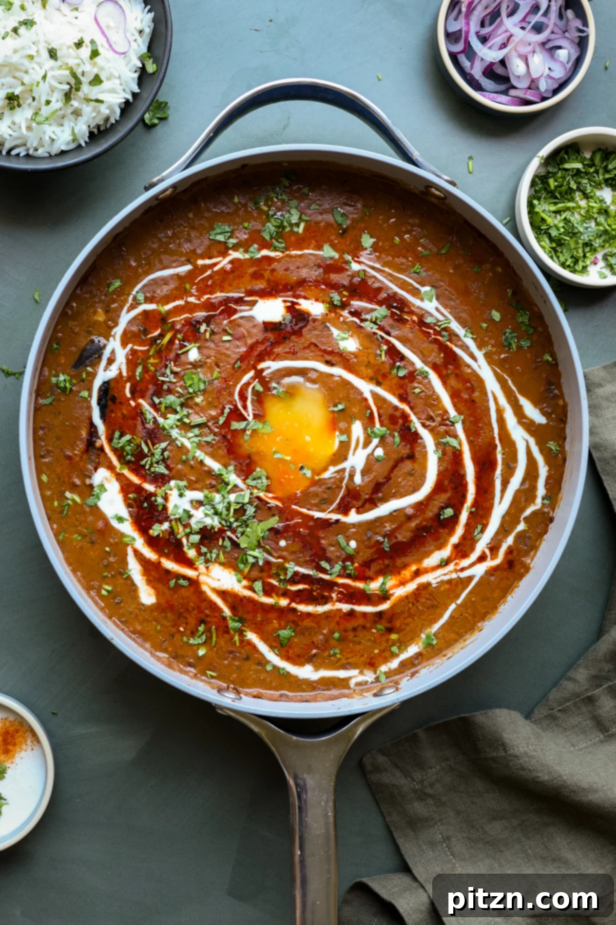Restaurant-Quality Dal Makhani at Home 2 A bubbling pot of Dal Makhani, adorned with a fresh tadka (tempering) and garnished with herbs.