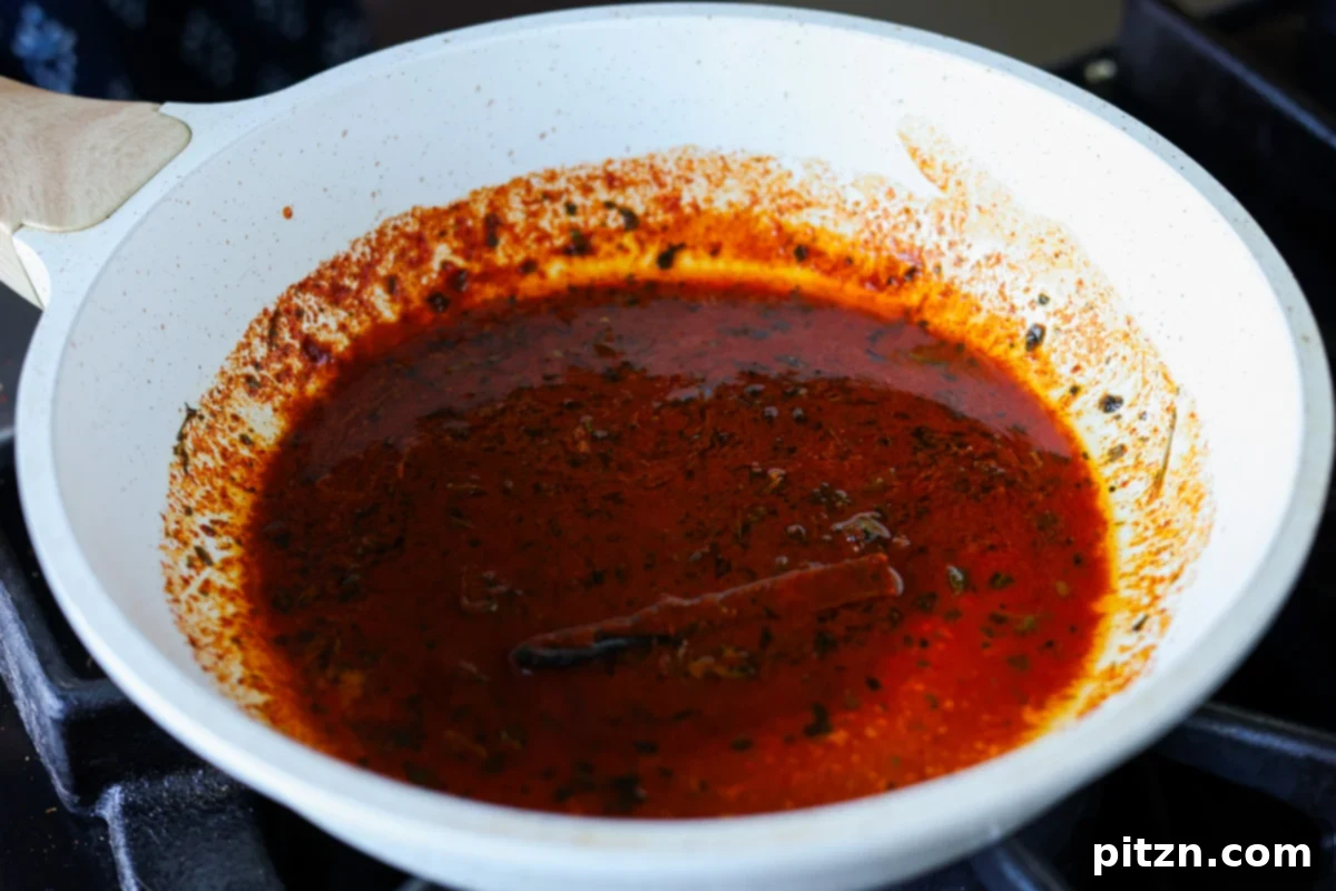 Restaurant-Quality Dal Makhani at Home 18 The spiced oil (tadka) in the small pan after the burnt cinnamon stick has been added, ready to be poured over the dal.
