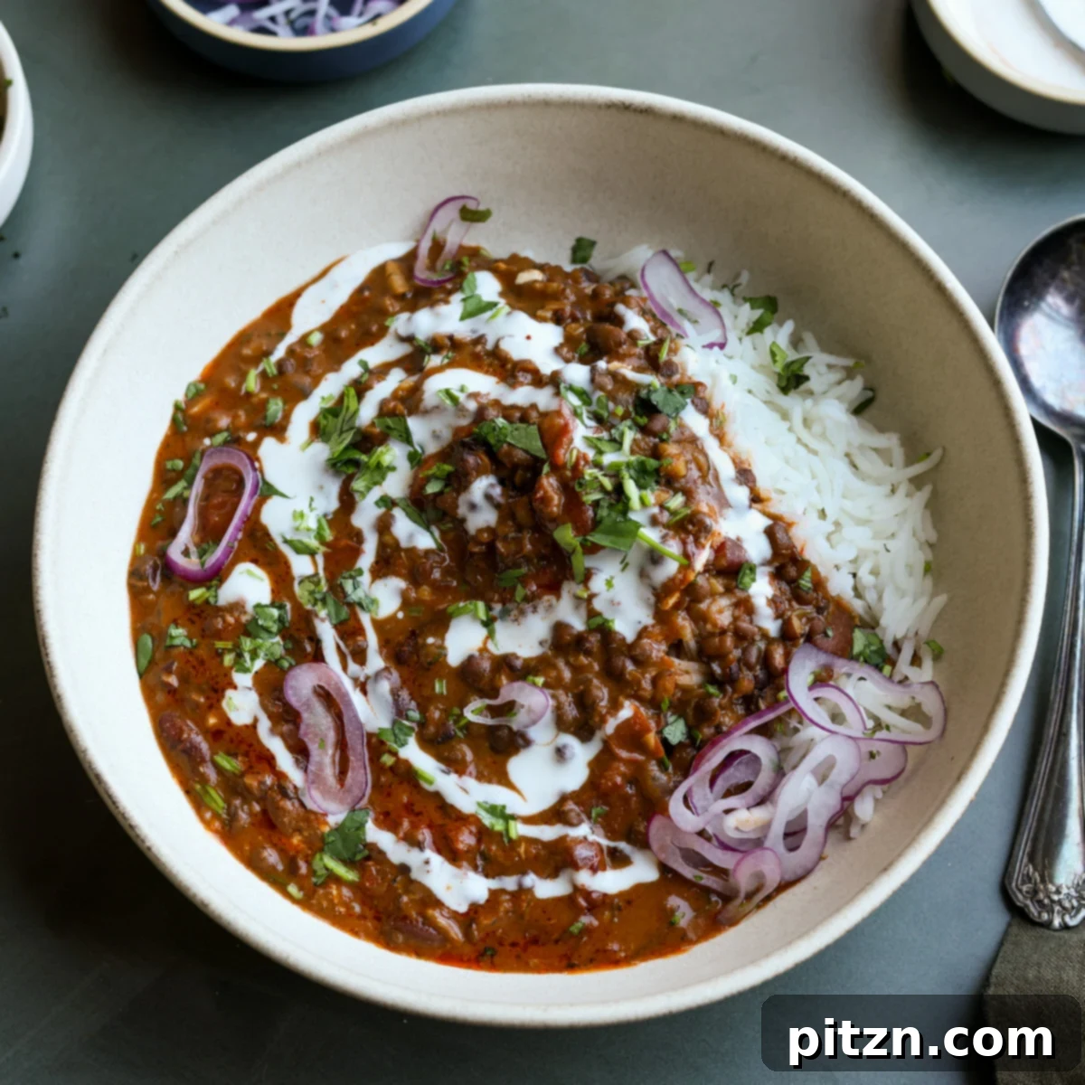 Restaurant-Quality Dal Makhani at Home 20 A beautifully presented bowl of creamy Dal Makhani, garnished with fresh cilantro and a swirl of cream, ready to be served.
