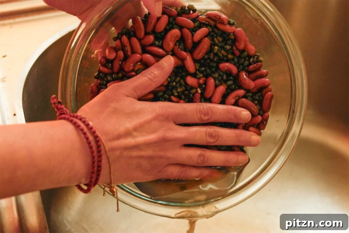Restaurant-Quality Dal Makhani at Home 6 Close-up of black gram and kidney beans being washed thoroughly in a bowl.