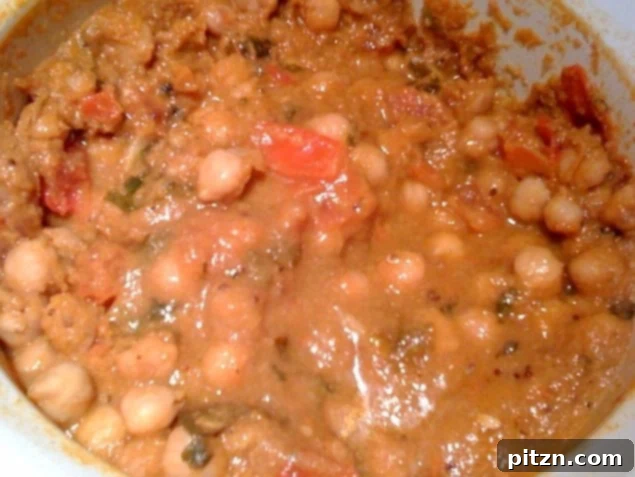 A vibrant bowl of Kadhai Chole, a rich chickpea curry, garnished with fresh cilantro.