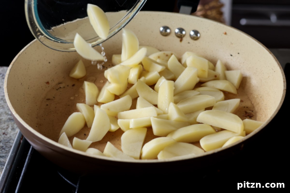 adding potatoes to the pan