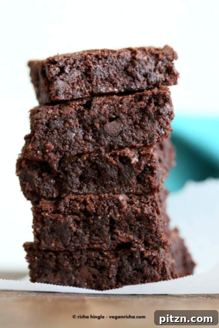 Decadent Vegan Gluten Free Brownies Made Easy 12 A stack of rich, fudgy Gluten-Free Vegan Brownies on a rustic wooden board.
