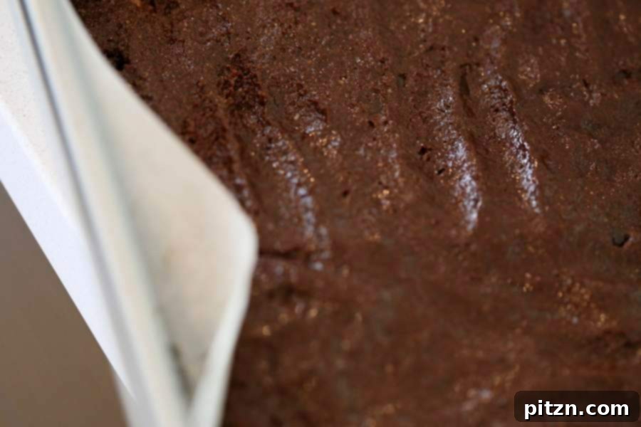 Decadent Vegan Gluten Free Brownies Made Easy 8 Spreading thick brownie batter into a parchment-lined brownie pan.