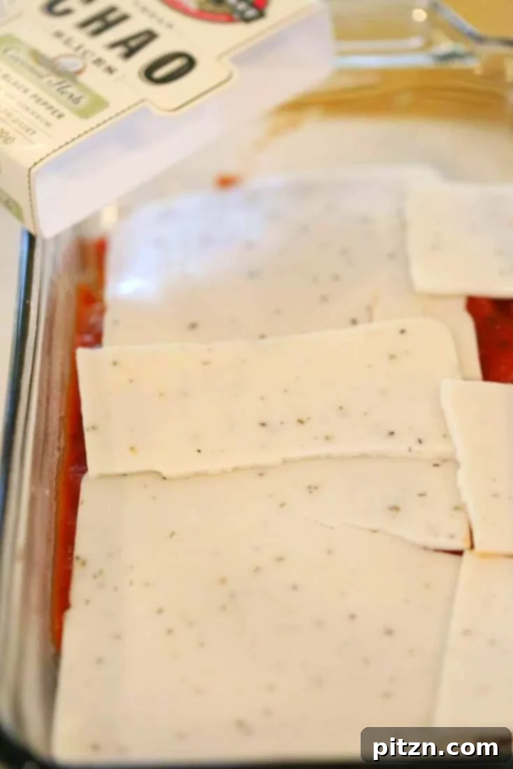 Cozy Vegan Veggie Lasagna for Two 6 A layer of delicious pasta sauce topped with vegan Chao cheese slices, known for their incredible melting ability, creating a creamy texture.