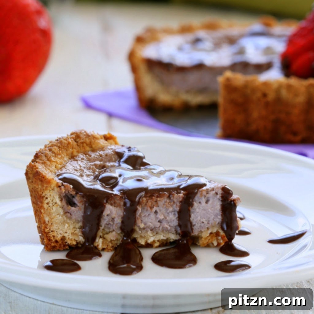 Two exquisite vegan strawberry cheesecake tarts topped with fresh strawberries and chocolate drizzle