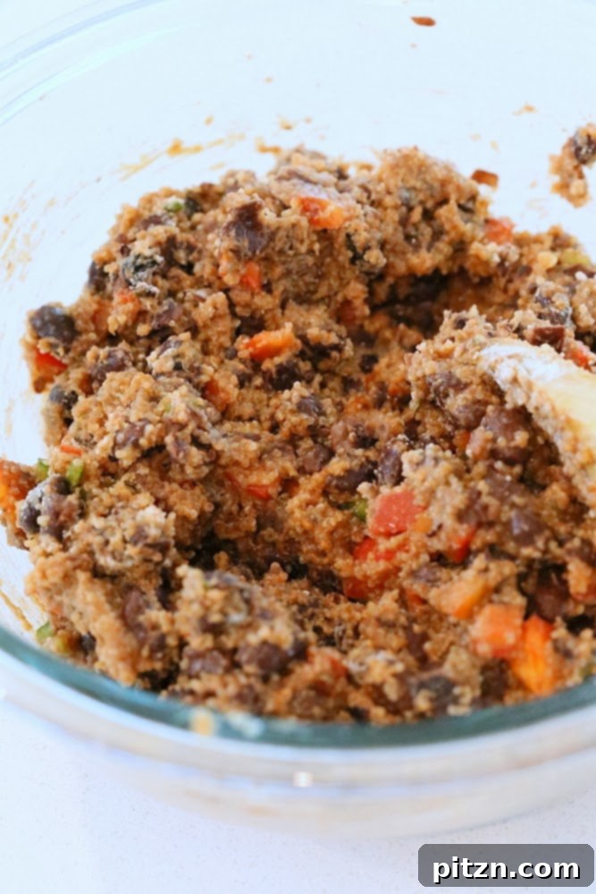 Mixture of amaranth and black beans being mashed in a bowl