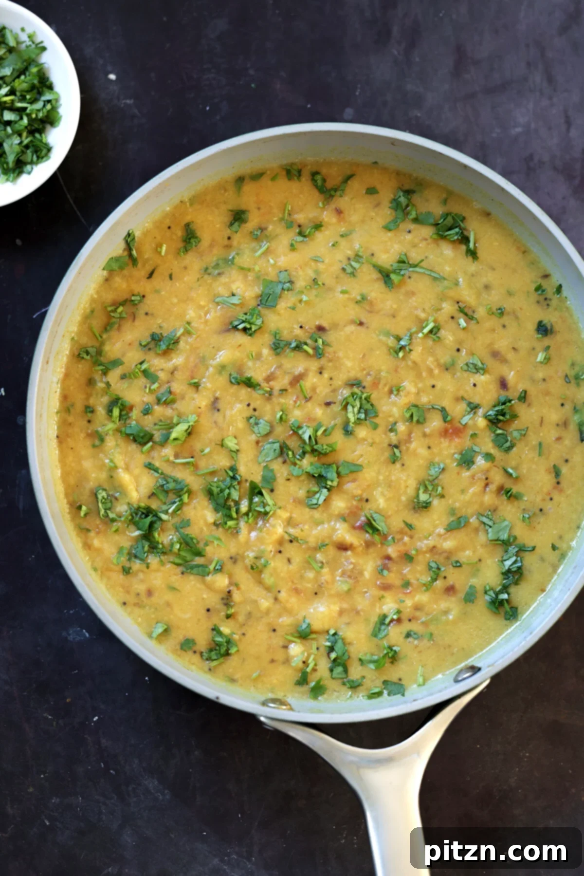 Dal Fry in a pan, garnished with fresh cilantro