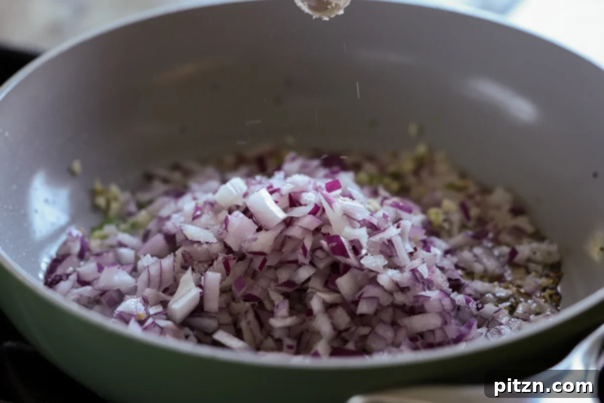 Adding chopped onion to the pan with other aromatics