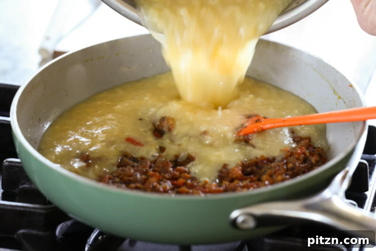 Adding the cooked lentils to the tempering in the skillet