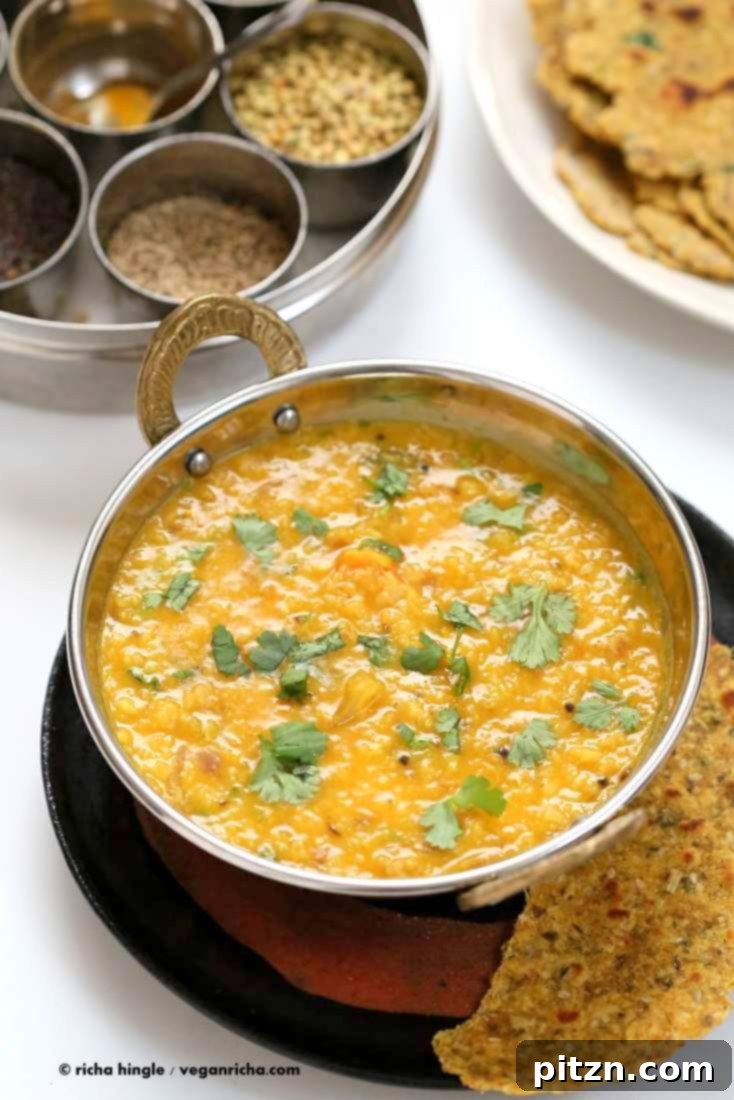 Dal Fry served in a bowl with a crispy papadum on the side