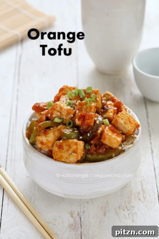 Overhead shot of the complete dish: Spicy Vegan Orange Tofu and Peppers, served beautifully in a bowl with rice.