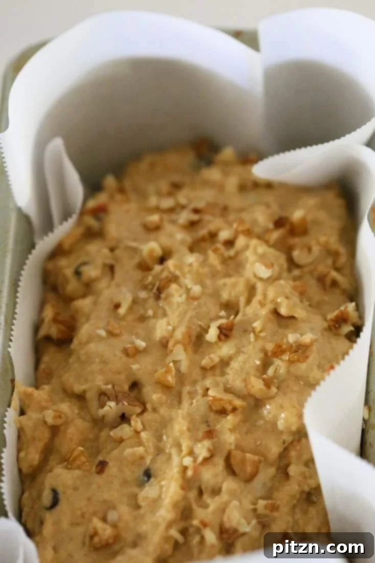 Delicious One-Bowl Vegan Banana Apple Loaf 7 Folding in shredded apple and optional vegan chocolate chips into the banana bread batter for a delightful One Bowl Vegan Banana Apple Loaf.