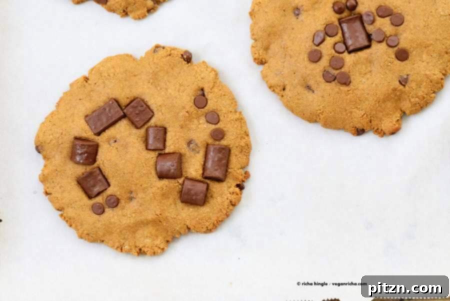 A tray of freshly baked vegan pumpkin chocolate chip cookies, with some decorated for Halloween.