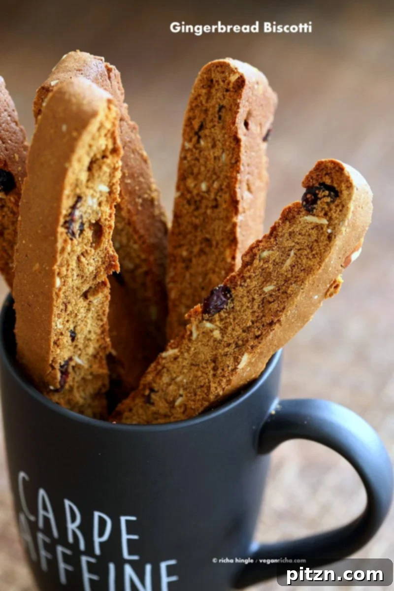 Vegan Gingerbread Biscotti with cranberries, almonds, candied ginger. Easy Crispy Spiced Biscotti Recipe to dunk in a cup of tea. Drizzle with white or dark chocolate. | VeganRicha.com #vegan #gingerbread #biscotti #recipe