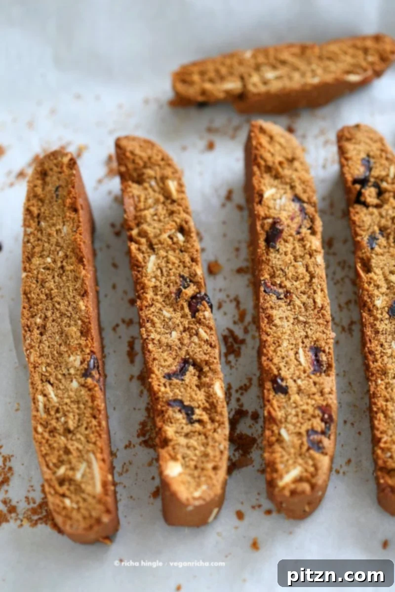 Vegan Gingerbread Biscotti with cranberries, almonds, candied ginger. Easy Crispy Spiced Biscotti Recipe to dunk in a cup of tea. Drizzle with white or dark chocolate. | VeganRicha.com #vegan #gingerbread #biscotti #recipe