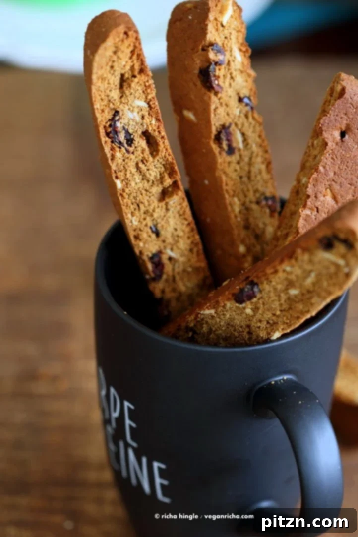 Vegan Gingerbread Biscotti with cranberries, almonds, candied ginger. Easy Crispy Spiced Biscotti Recipe to dunk in a cup of tea. Drizzle with white or dark chocolate. | VeganRicha.com #vegan #gingerbread #biscotti #recipe