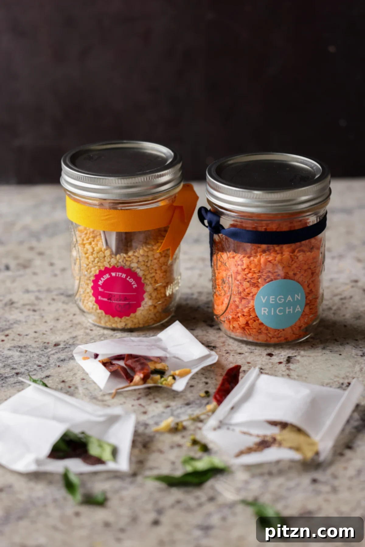 Dal Tadka Lentil Soup Mix in a Jar 2 Open jars of lentil soup mix with open spice pouches showcasing layered ingredients.