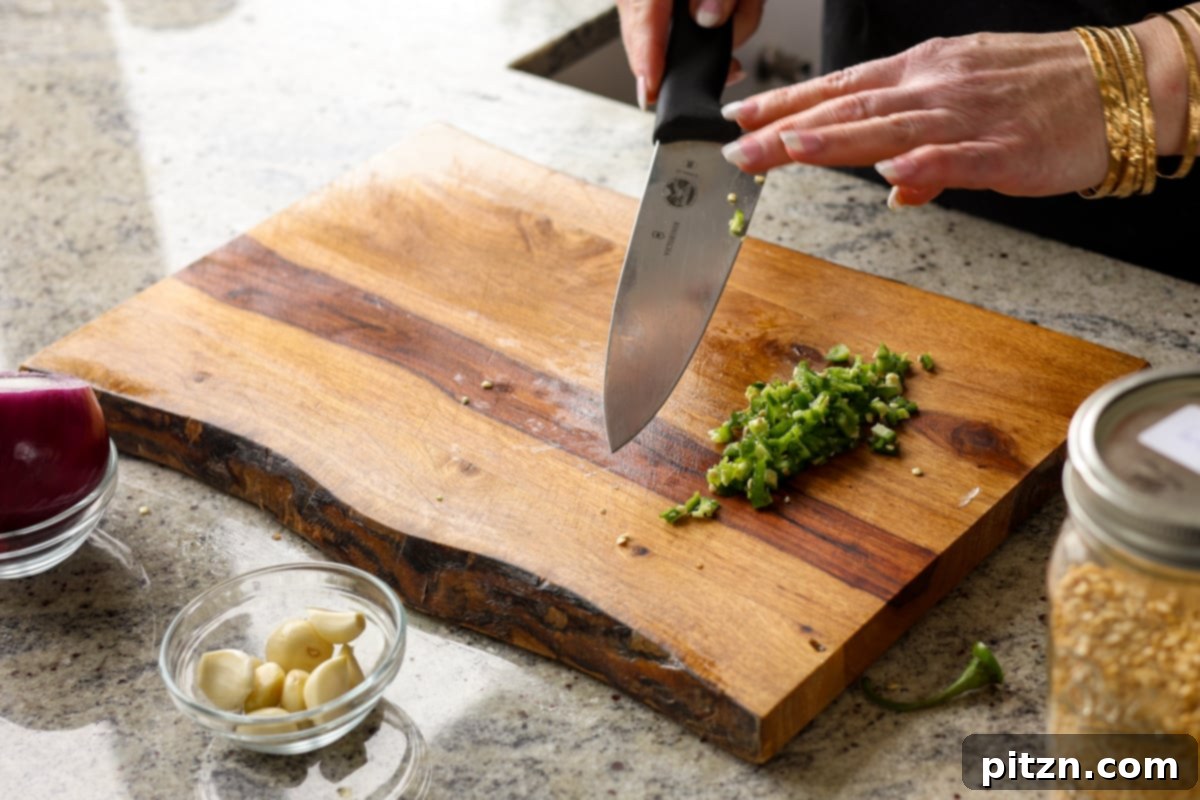 Dal Tadka Lentil Soup Mix in a Jar 11 Chopping a vibrant green chili on a cutting board.