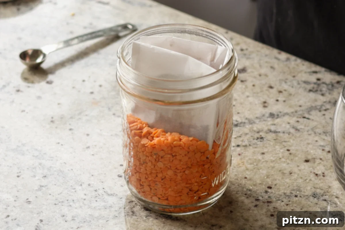 Dal Tadka Lentil Soup Mix in a Jar 21 Placing prepared spice pouches into a mason jar with lentils.