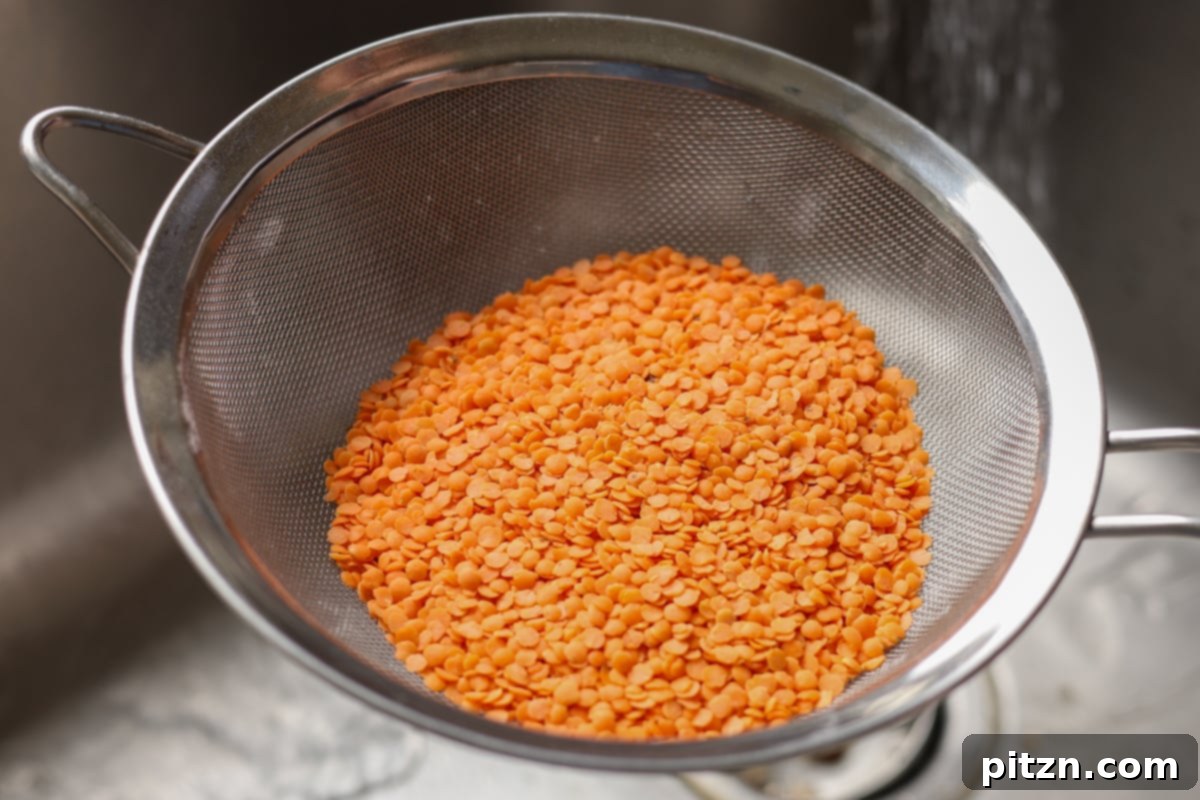 Dal Tadka Lentil Soup Mix in a Jar 23 Rinsing red lentils thoroughly under running water in a colander.