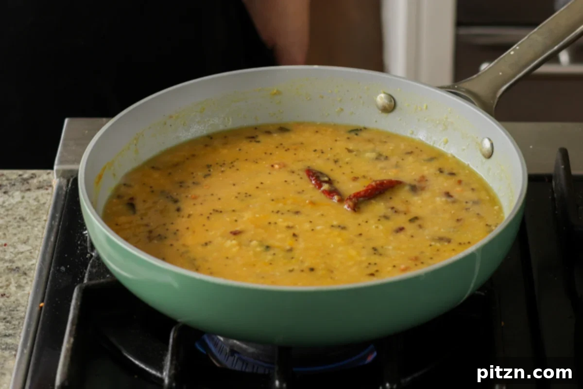 Dal Tadka Lentil Soup Mix in a Jar 30 Finished dal tadka, rich and creamy, served in a bowl after cooking.